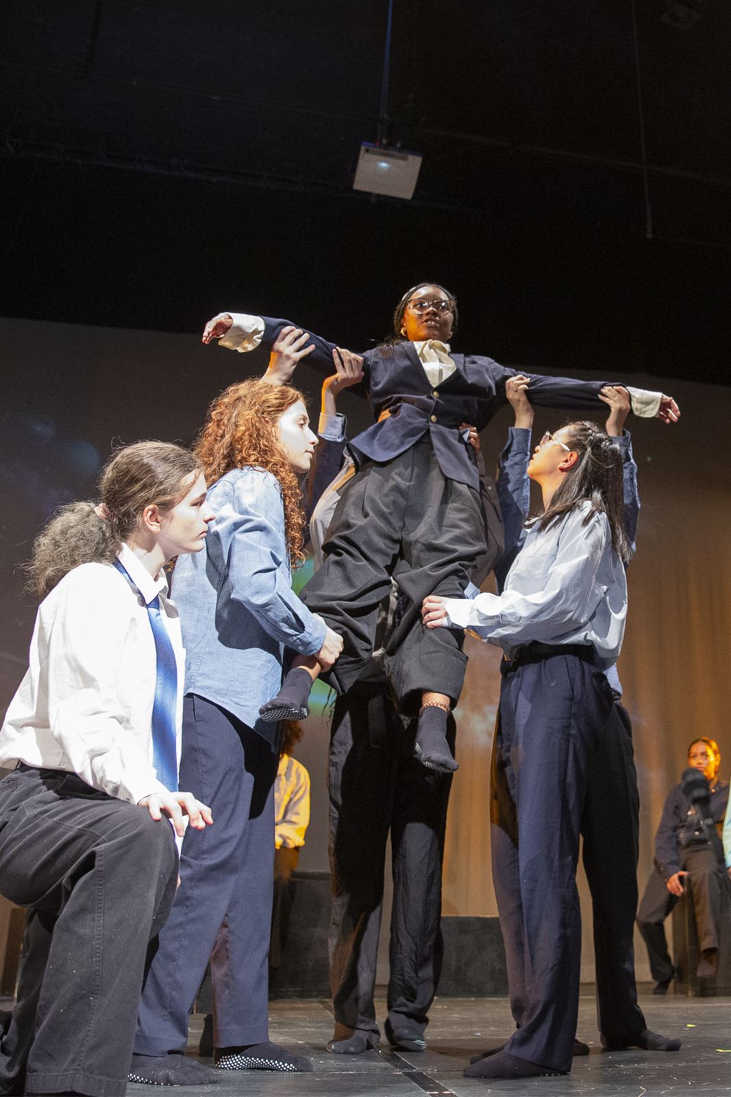 Teen performers lift a castmate overhead in Empowerland, Spring 2026