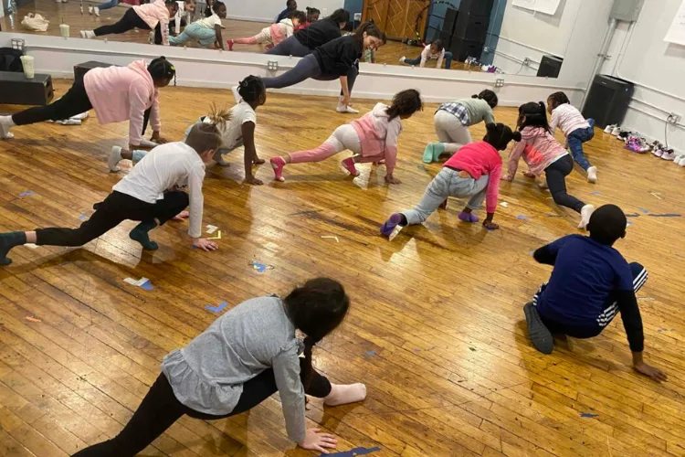 Students stretch on the studio floor during a BCT class